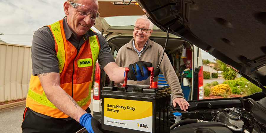 RAA patrol replacing a member's car battery as the member watches on